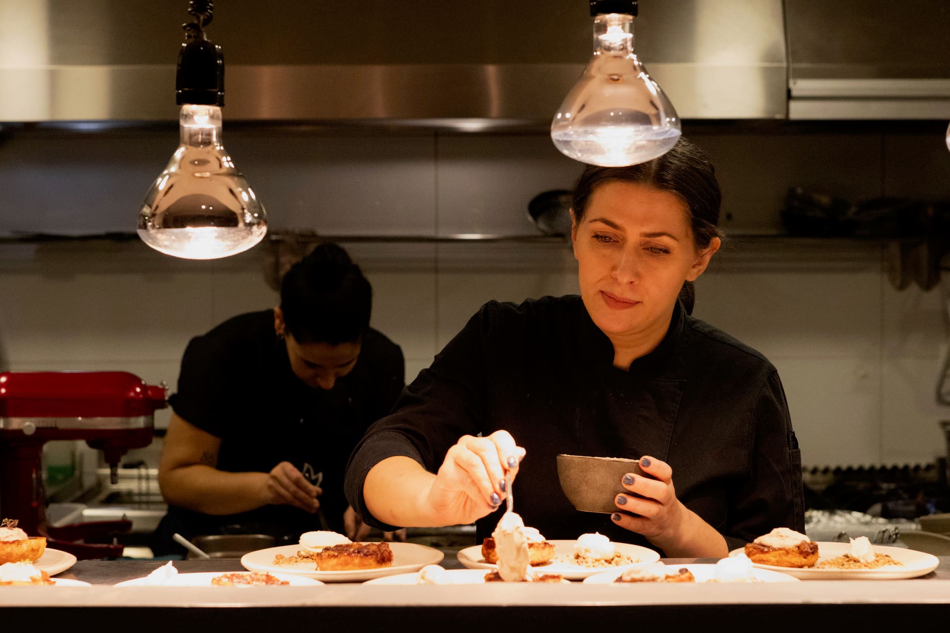 Elena working alongside a sous chef at the pass